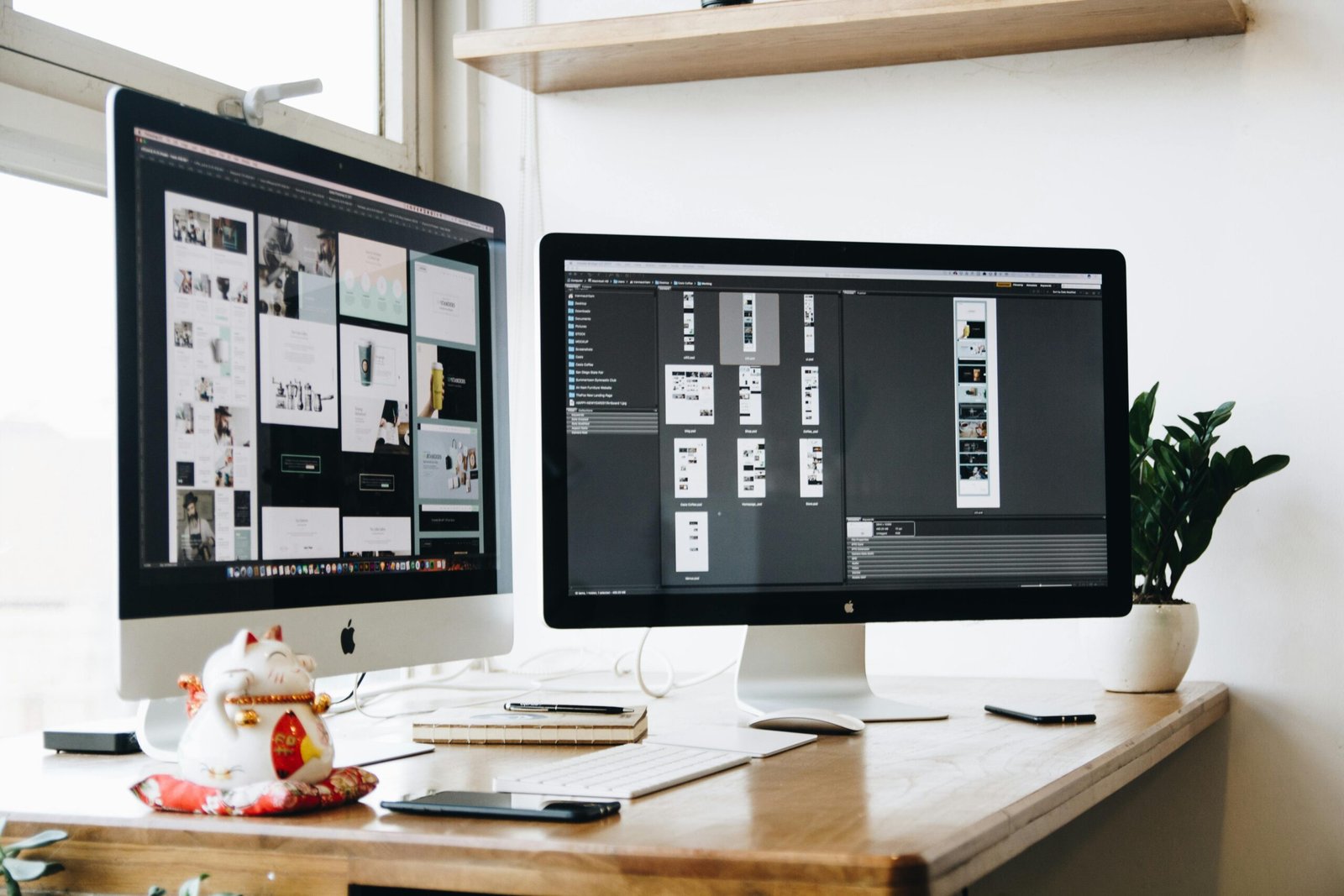 Biurko z dwoma monitorami prezentującymi projekty stron internetowych – praca agencji marketingowej nad optymalizacją i designem